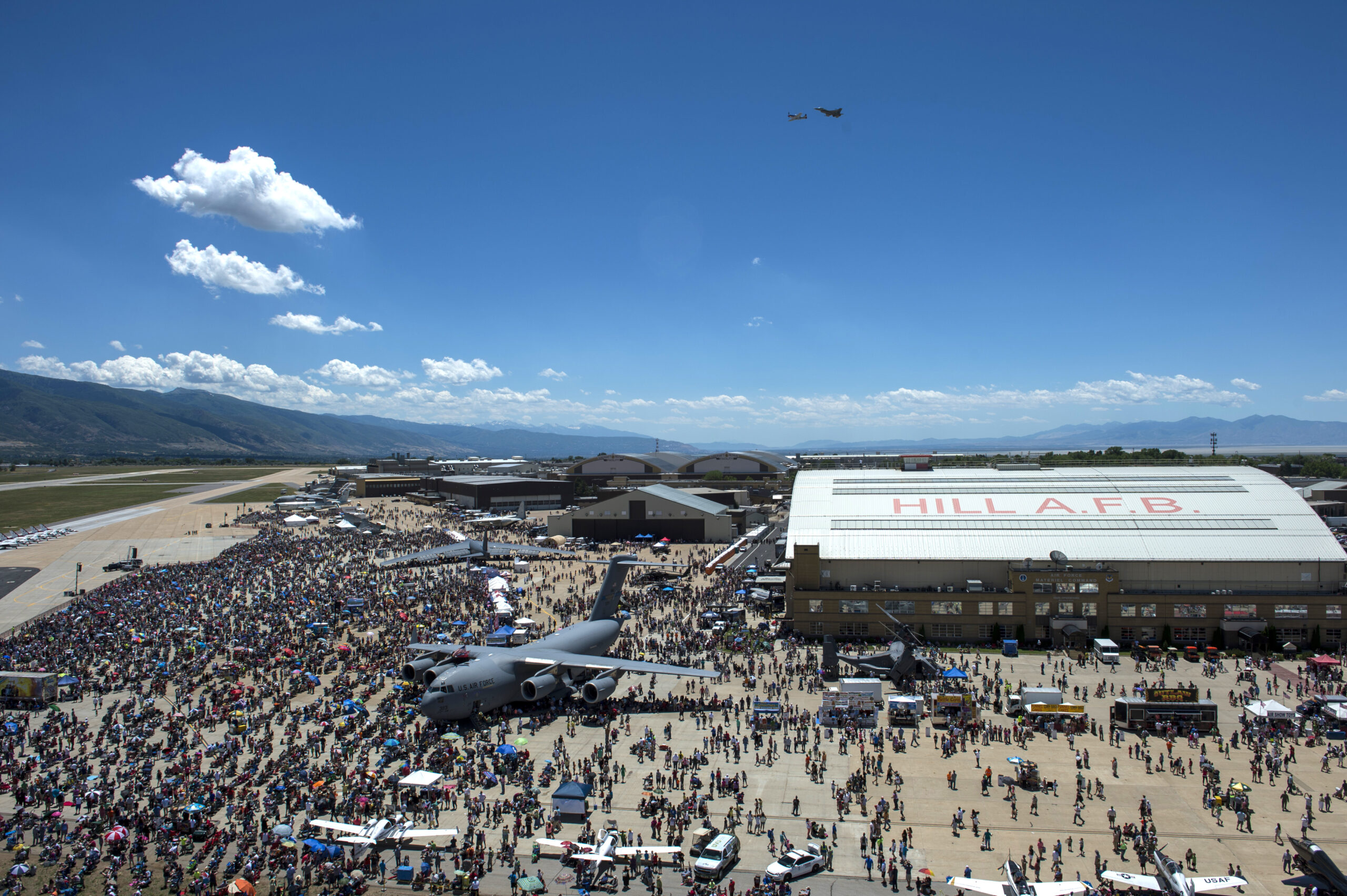 A P-51 Mustang flies side by side with an F-16 Fighting Falcon over the crowd June 28, 2014, during the Warriors Over the Wasatch Air Show at Hill Air Force Base, Utah. The Warriors Over the Wasatch air show was open to the public June 28 and 29. Events during the show include the U.S. Army parachute team, the Golden Knights; an F-16 attack demonstration by the 388th Fighter Wing and a precision air demonstration by the Thunderbirds. (U.S. Air Force photo/Airman 1st Class Taylor Queen.)