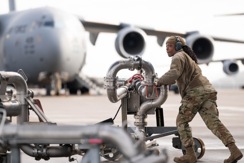 A U.S. Air Force Staff Sergeant of the 86th Logistic Readiness Squadron, packs up a pantograph fueling system after completing a refueling job at Ramstein Air Base, Germany, Jan. 31, 2024. The in-ground fuels system allowed Cash to pump the aircrafts nearly 32,000 gallon tank by herself, saving the 86th LRS from needing to send multiple fuel trucks and Airmen to accomplish the job. (U.S. Air Force photo by Senior Airman Andrew Bertain.)