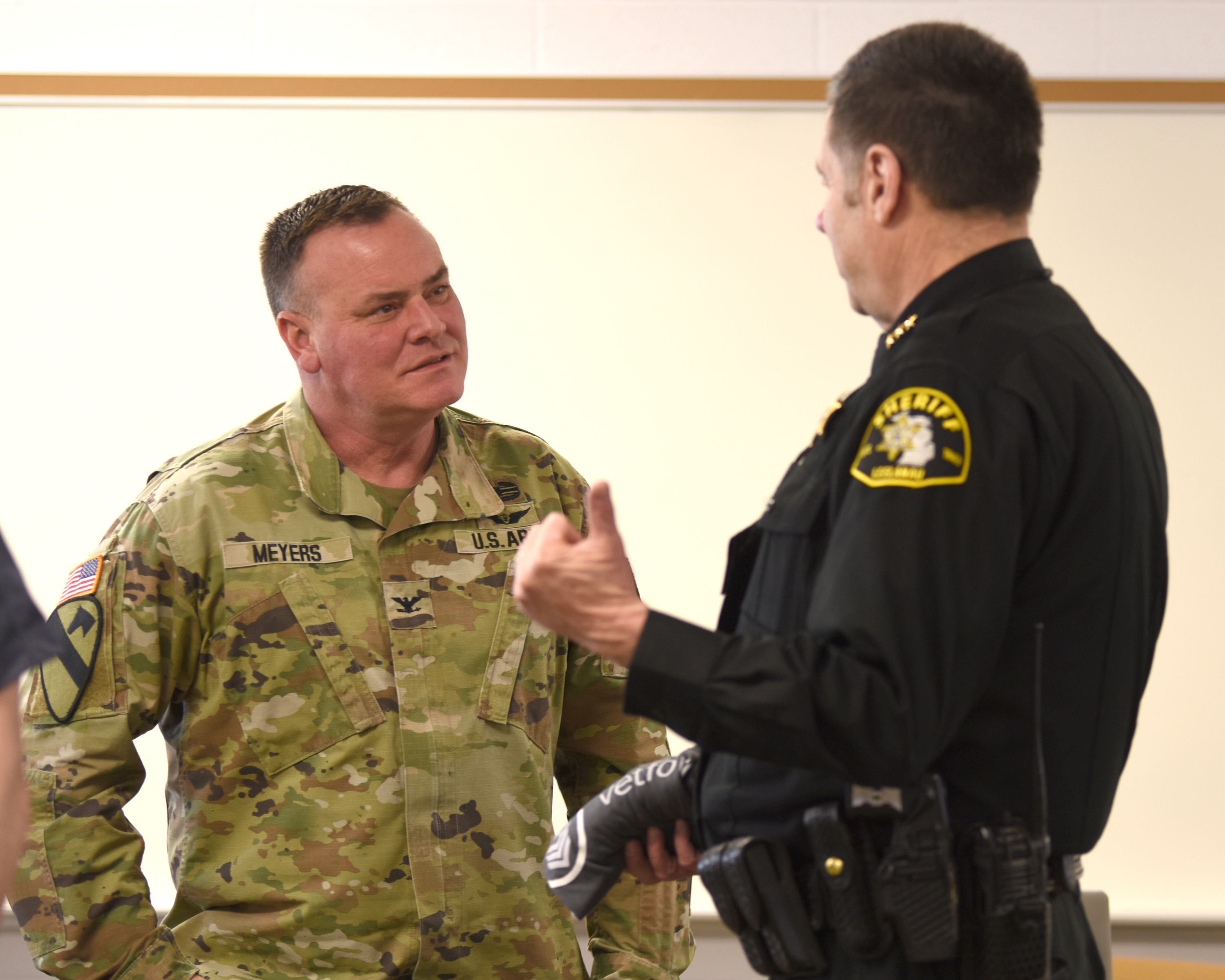 U.S. Army Col. and commander, Camp Grayling Joint Maneuver Training Center, Michigan Army National Guard, discuss cyber attacks during a cyber-warfare training event, Camp Grayling Joint Maneuver Training Center, Michigan, March 8, 2022. The Cyber Strike exercise focused on replicating a live training environment utilizing key personnel from different organizations consisting of law enforcement, prosecutors, detectives, and the Michigan Air National Guard and used a closed network that ran a malware application. (U.S. Air National Guard photo by Master Sgt. David Eichaker.)