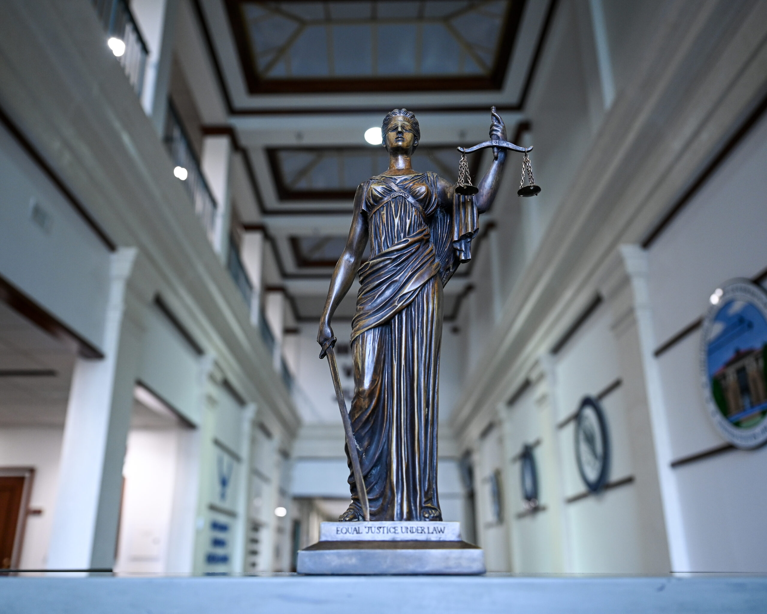 A statue of Lady Justice stands inside the Judge Advocate General’s School at Maxwell Air Force Base, Alabama, June 5, 2025. Representing impartiality and the pursuit of truth, Lady Justice holds balanced scales and a sword, symbols of fairness and legal authority in the U.S. Air Force legal system. (U.S. Air Force photo by Airman 1st Class Nelvis Sera.)