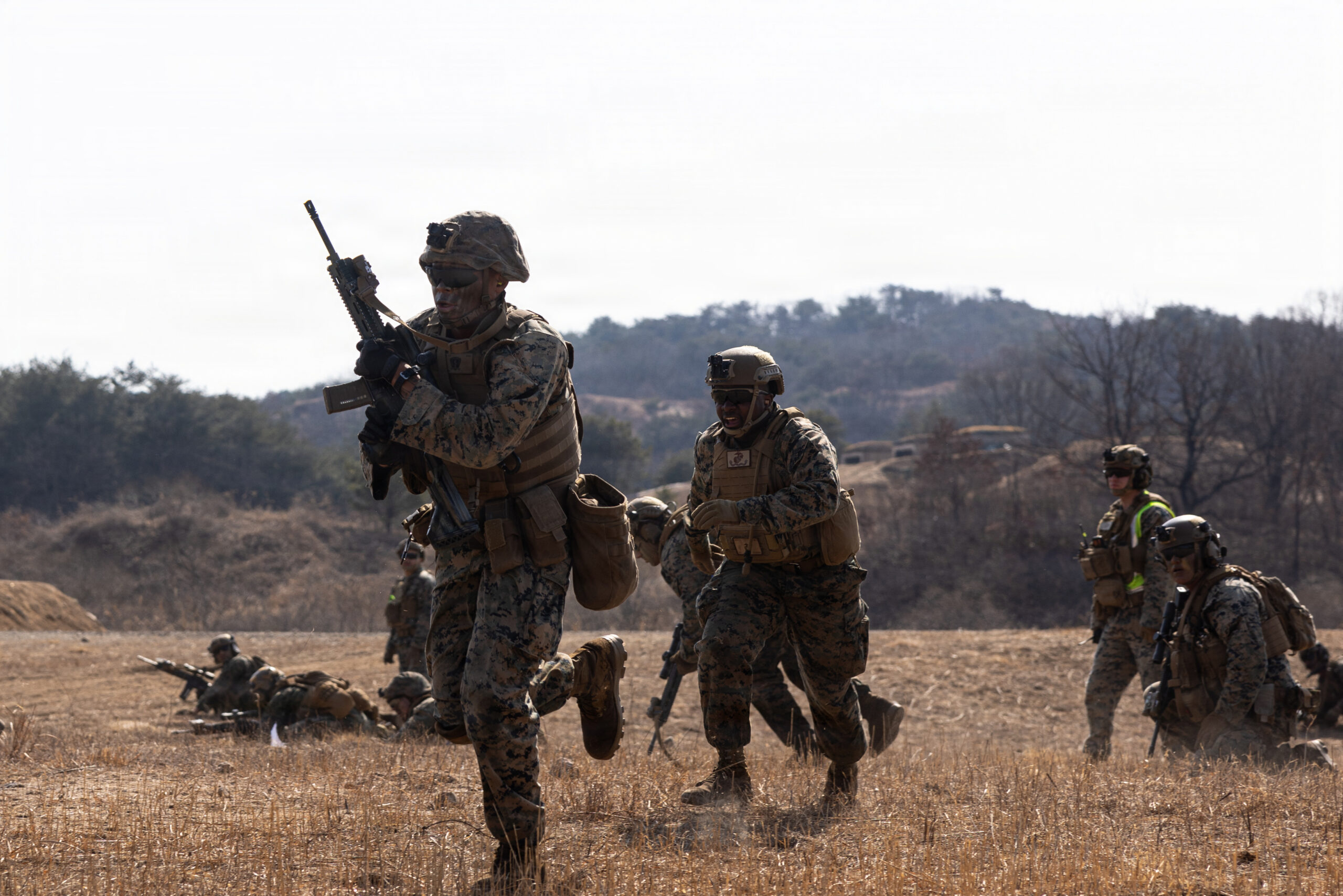 U.S. Marine Corps Lance Cpl. and rifleman with 12th Littoral Combat Team, 12th Marine Littoral Regiment, 3rd Marine Division, sprints towards an objective during a Combined Arms Live-Fire Exercise at Rodriguez Live-Fire Complex, Republic of Korea, Feb. 28, 2026. 12th LCT Marines executed a company-level CALFEX, integrating organic and supporting fires, maneuver elements, and reconnaissance capabilities to conduct a coordinated assault on a designated objective. The range strengthened the unit’s ability to synchronize fires and movement in a dynamic training environment while enhancing combat effectiveness and overall readiness. Evans is a native of Maryland. (U.S. Marine Corps photo by Lance Cpl. Robert Blanks.)